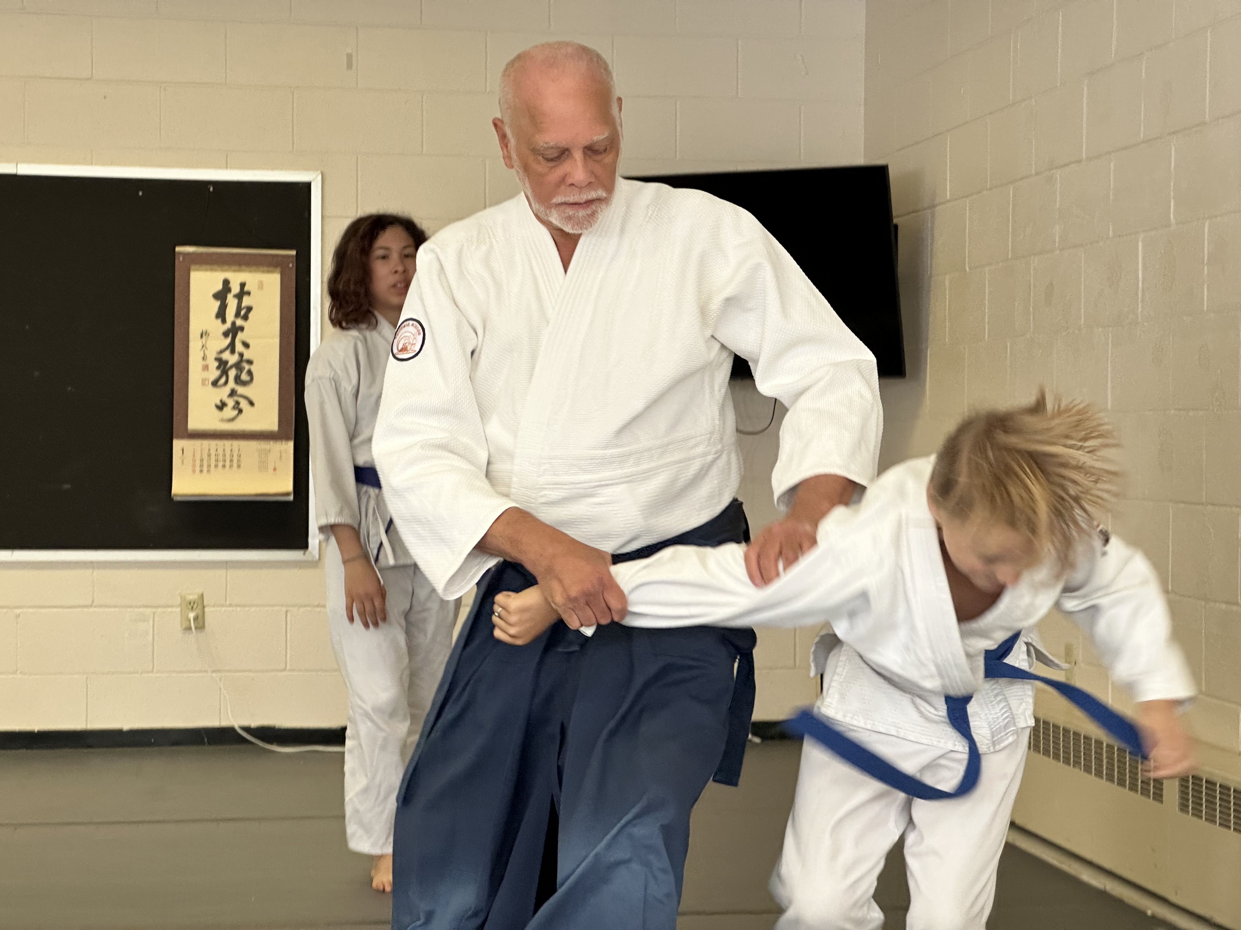 Sensei guiding a young student through a technique
